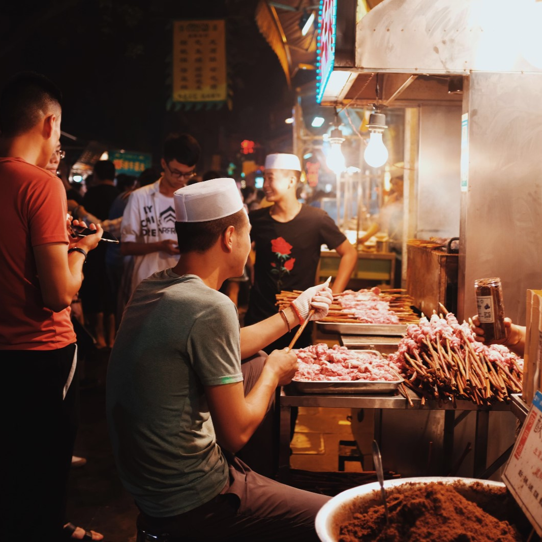 A night-market kitchen in Xi'an's Muslim Quarter, cooks at the grills