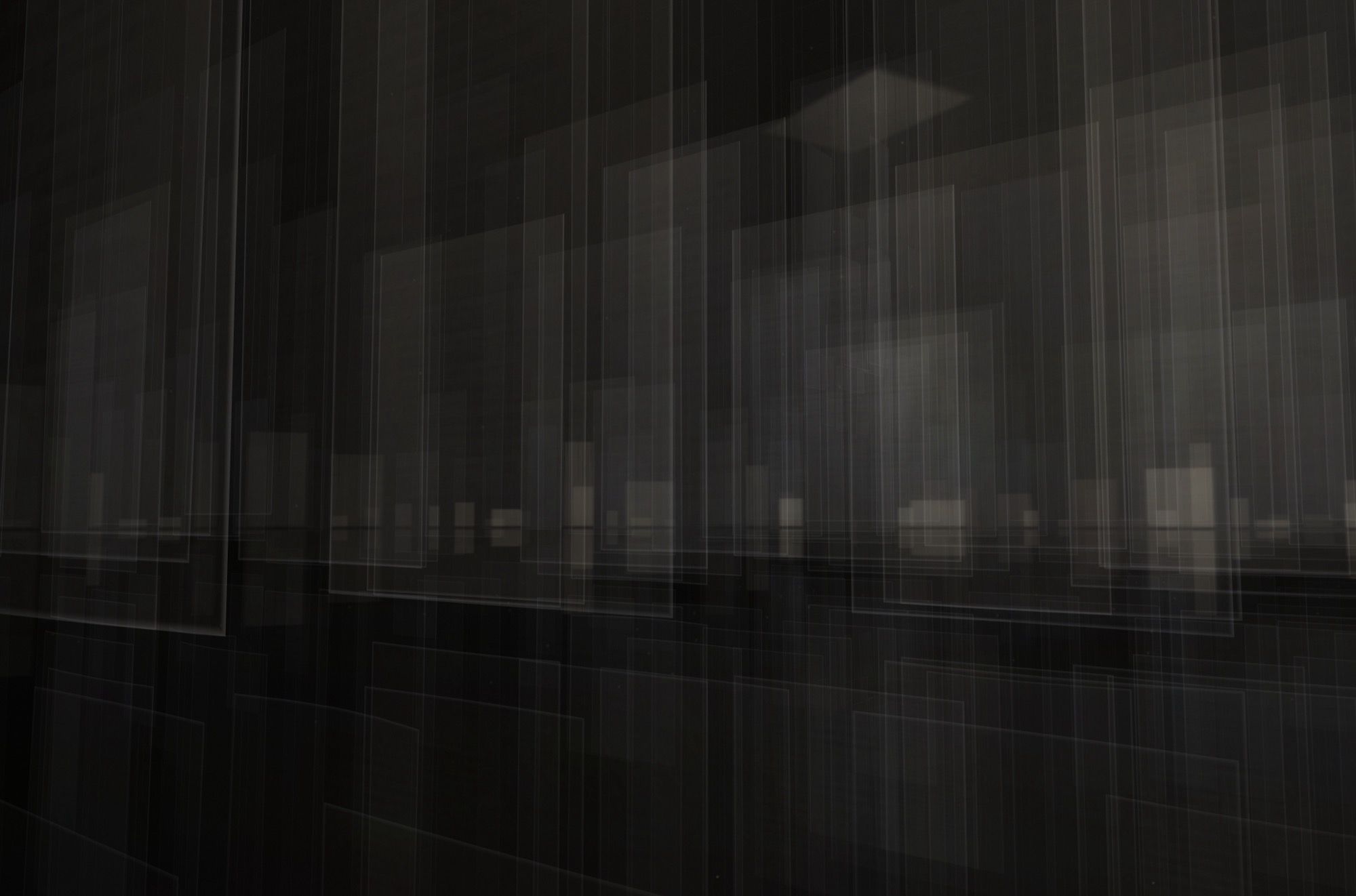 Sheets in the foreground before a horizon of small lit rectangles, mirrored in the dark water below